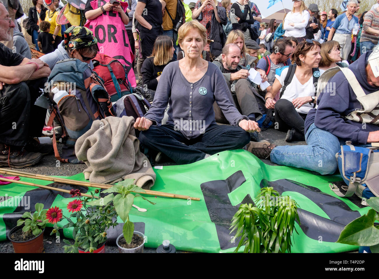 Extinction Rebellion Aktivisten besetzen Waterloo Bridge im April 2019: Eine reife Protesterin meditiert, bevor die Polizei mit Verhaftungen beginnt. Stockfoto