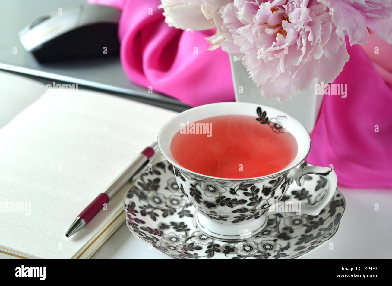 Elegant Gestalteten weiblichen Desktop - Entspannung, Lesen, kreatives Schreiben, Lernen und Journaling Konzept mit rosa Pfingstrosen, Obst Kaffee schickes Zubehör Stockfoto