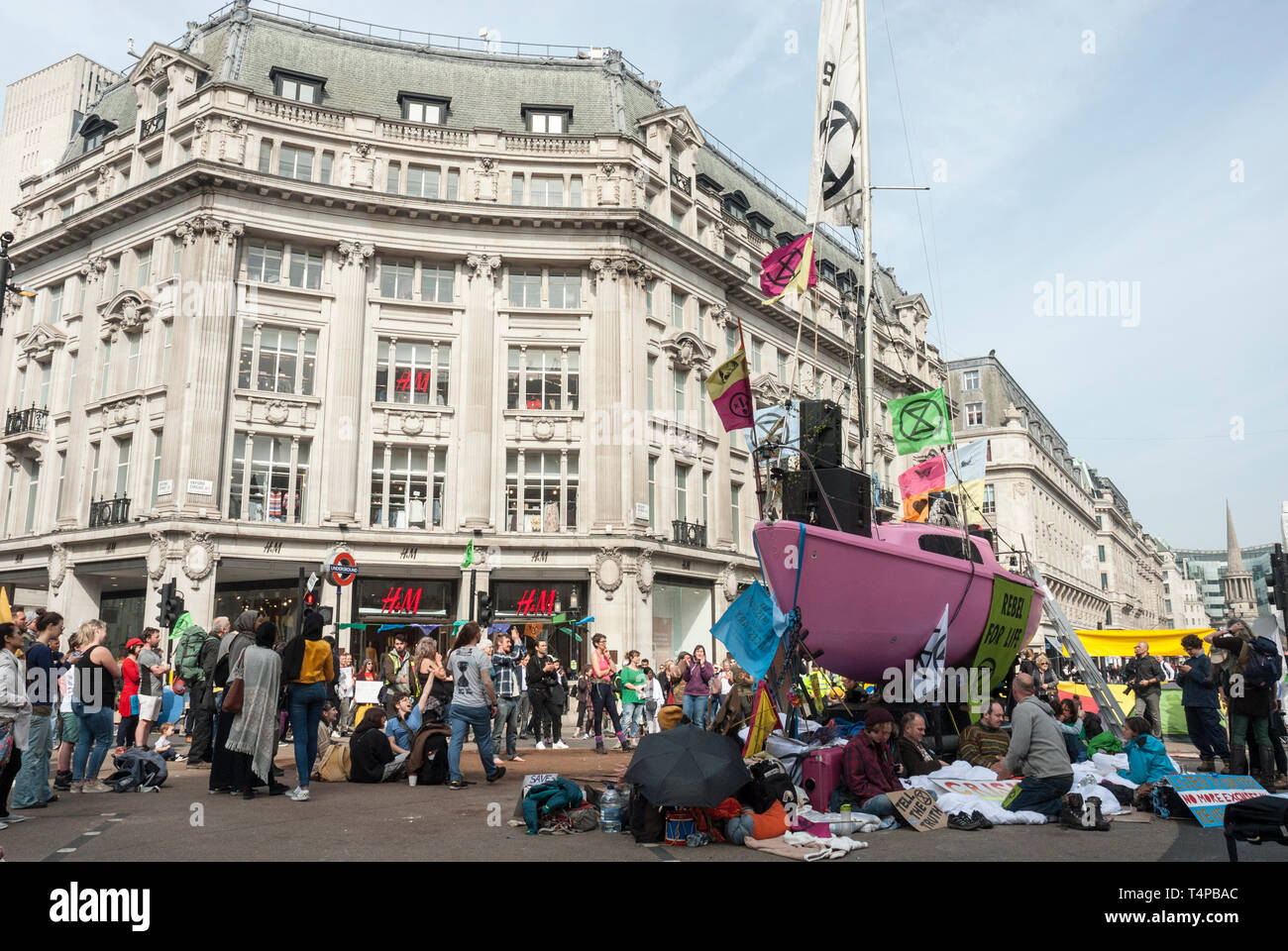 "Demonstranten Aussterben Rebellion" gegen den Klimawandel blockieren und Oxford Circus mit einem hellen Rosa Yacht geschmückt mit Flaggen und Poster besetzen. Stockfoto