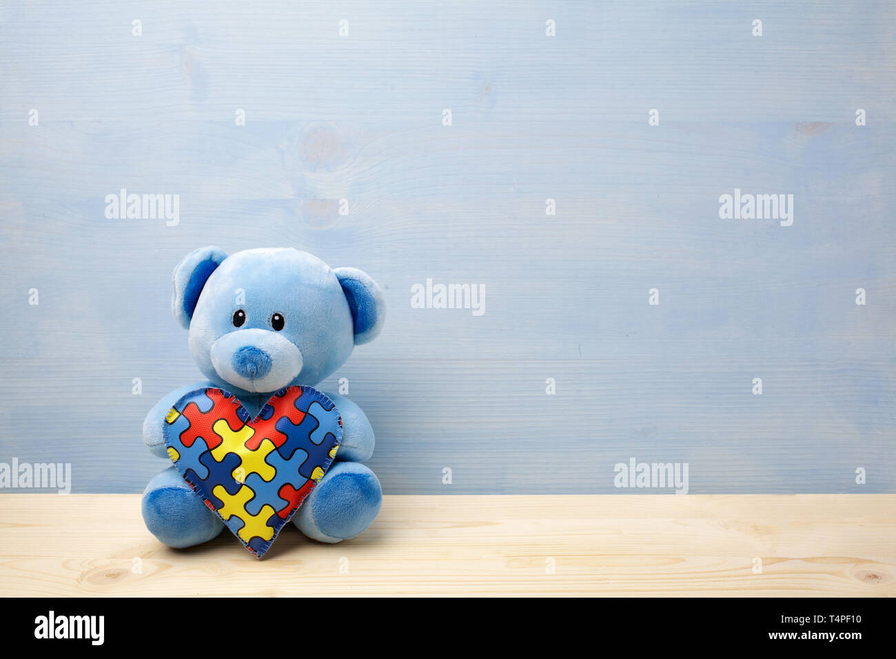 Welt Autismus Bewußtsein Tag, Konzept mit Teddybär holding Puzzle oder Stichsäge Muster auf Herz Stockfoto