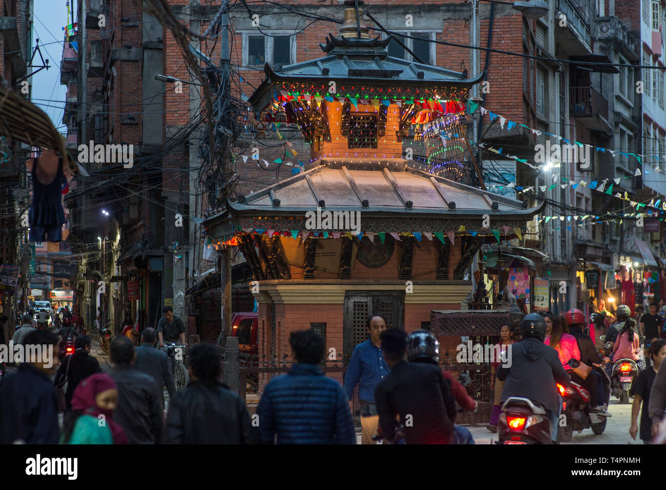 Eine geschäftige Straße mit einem buddhistischen Tempel in der Innenstadt von Kathmandu, Nepal, am späten Nachmittag. Stockfoto