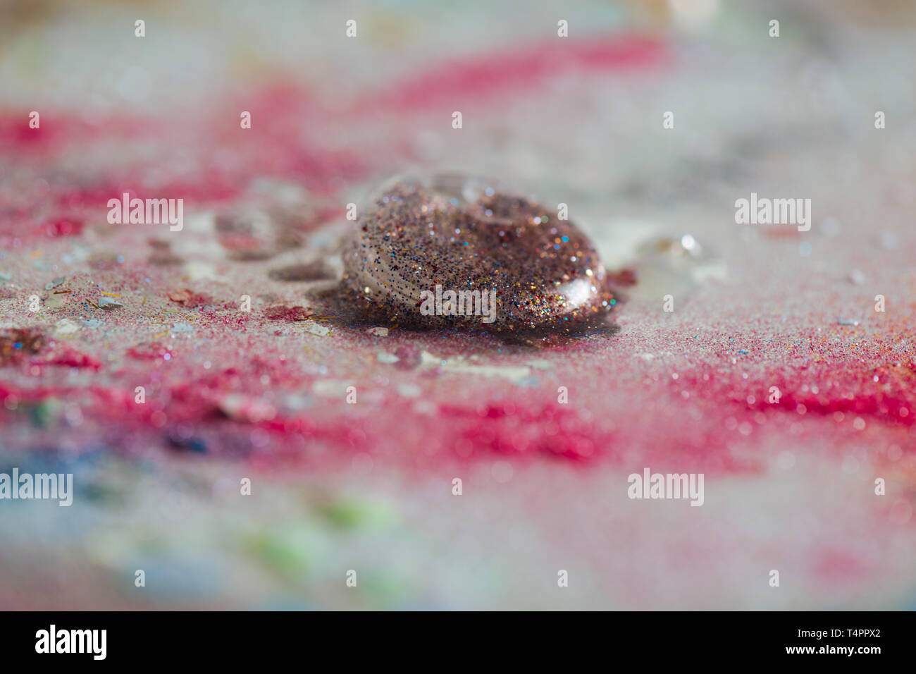 Hell funkeln. Schöne bunte Blase mit Glitter leaved innen auf einen schmutzigen Tisch mit Verwirrung um Stockfoto