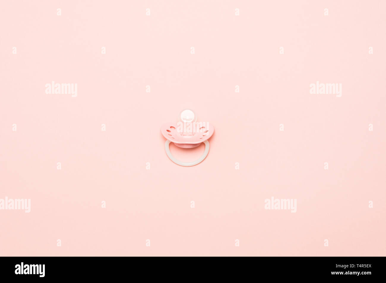 Rosa Baby Silikon Schnuller mit Ring auf rosa Hintergrund. Symbol der neugeborenen Babys. Minimalistischer Stil. Kopieren Sie Platz. Flach Stockfoto