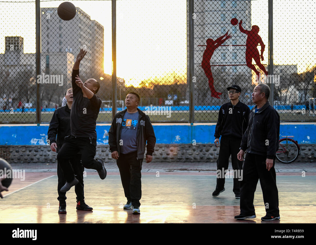 (190418) - - Urumqi, April 18, 2019 (Xinhua) - Leute spielen Basketball am Morgen um Shihezi Universität in Shihezi, Nordwesten Chinas Autonome Region Xinjiang Uygur, 10. April 2019. Shihezi, rund 150 Kilometer nordwestlich von Urumqi, ist eine junge Stadt, die in den 1950er Jahren in der Wüste Gobi von Xinjiang gegründet wurde. Dank mehrerer Generationen "die Bemühungen von Xinjiang Menschen und Xinjiang Produktion und Konstruktion Korps, es hat eine schöne und entwickelte Stadt in der Autonomen Region geworden. Die städtische Grünfläche erreicht 2.580 Hektar hat, die Grünflächen in Parks erreicht hat, 341 Hektar, Stockfoto