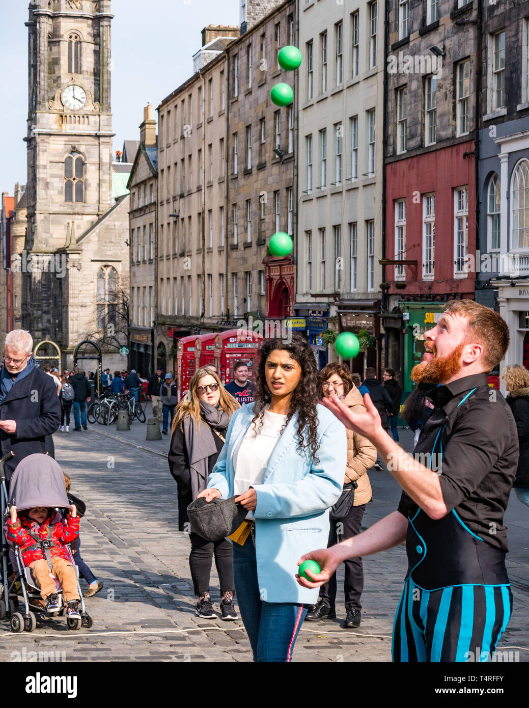 Royal Mile, Edinburgh, Schottland, Großbritannien, 18. April 2019. Die Menschen der Stadt auf einem warmen Frühling Tag genießen. Eine Street Performer jongliert Bälle und unterhält eine Masse in der Altstadt Stockfoto