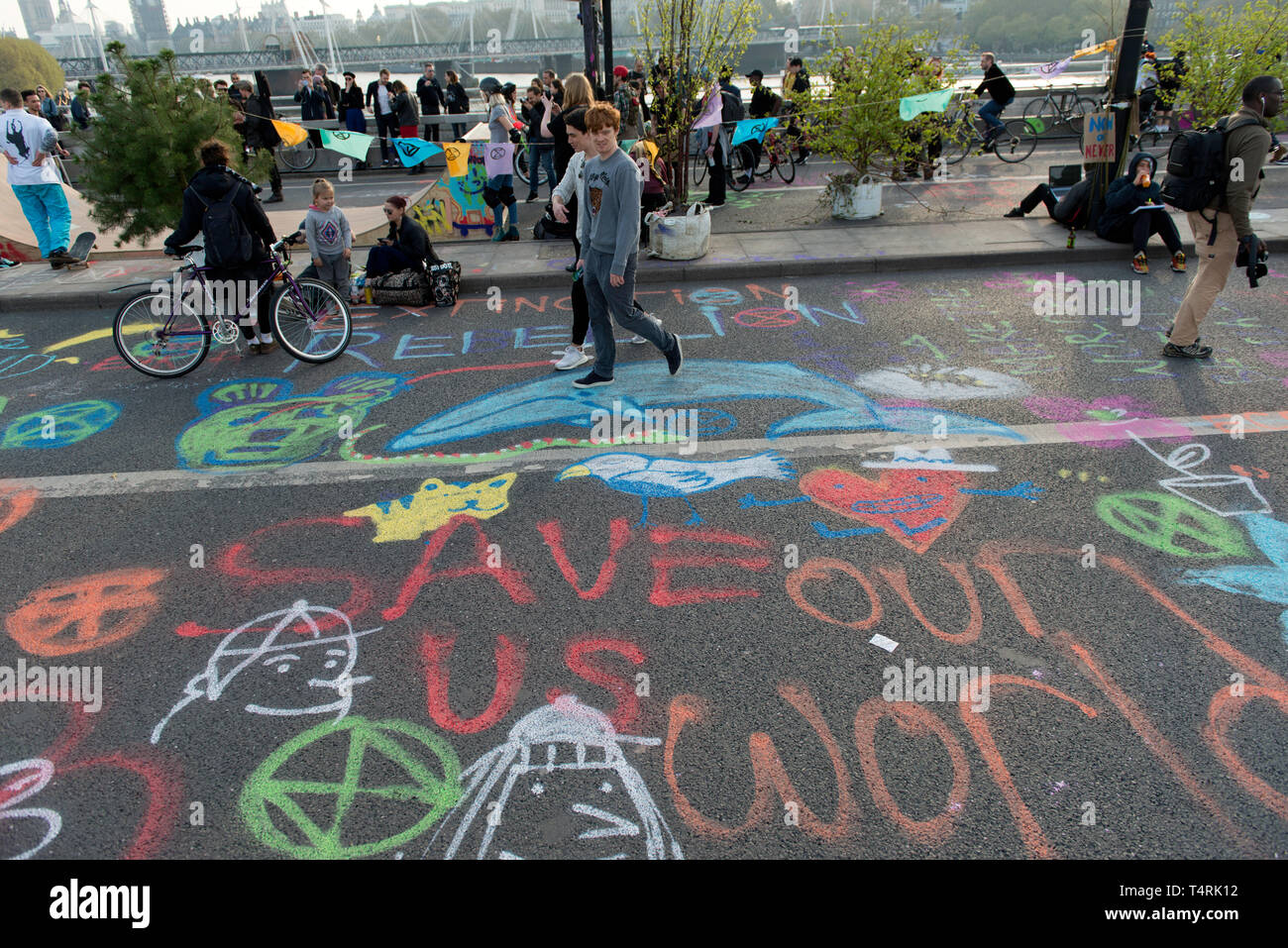 Menschen zu Fuß auf Graffiti von Demonstranten, die Waterloo Bridge in London während das Aussterben Rebellion Streik in London gesperrt. Umweltaktivisten vor dem Aussterben Aufstandsbewegung halten für vierten aufeinander folgenden Tag der Waterloo Bridge in London. Aktivisten wurde ein Lkw auf der Brücke die Straße blockieren, wodurch Unterbrechungen geparkt. Polizei verhaftete Demonstranten, die zu Marble Arch zu verweigern. Aussterben Rebellion fordert von der Regierung direkte Aktionen auf das Klima, die CO2-Emissionen bis 2025 auf Null zu reduzieren und die Völker. Stockfoto