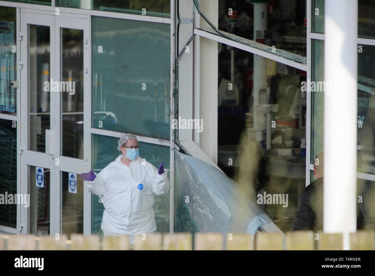 Crumlin, Großbritannien. 19 Apr, 2019. CRUMLIN, County Antrim, Nordirland, 19/April/2019 - Polizei aus der PSNI und Forensik kommen an einem der beiden Tatorten nach einem anderen ATM Diebstahl in einem Supermarkt in Crumlin Dorf, County Antrim. Ein Bagger war steigen und einen Traktor und Anhänger Set wurde auch heraus gefunden verbrannt Sperrung der Hauptstraße in die frühen Morgenstunden. Vier Geldautomaten, 3 aus Nordirland und einer aus dem Süden von Irland, wo in den frühen Morgenstunden gestohlen. Credit: Paul McErlane/Alamy leben Nachrichten Stockfoto