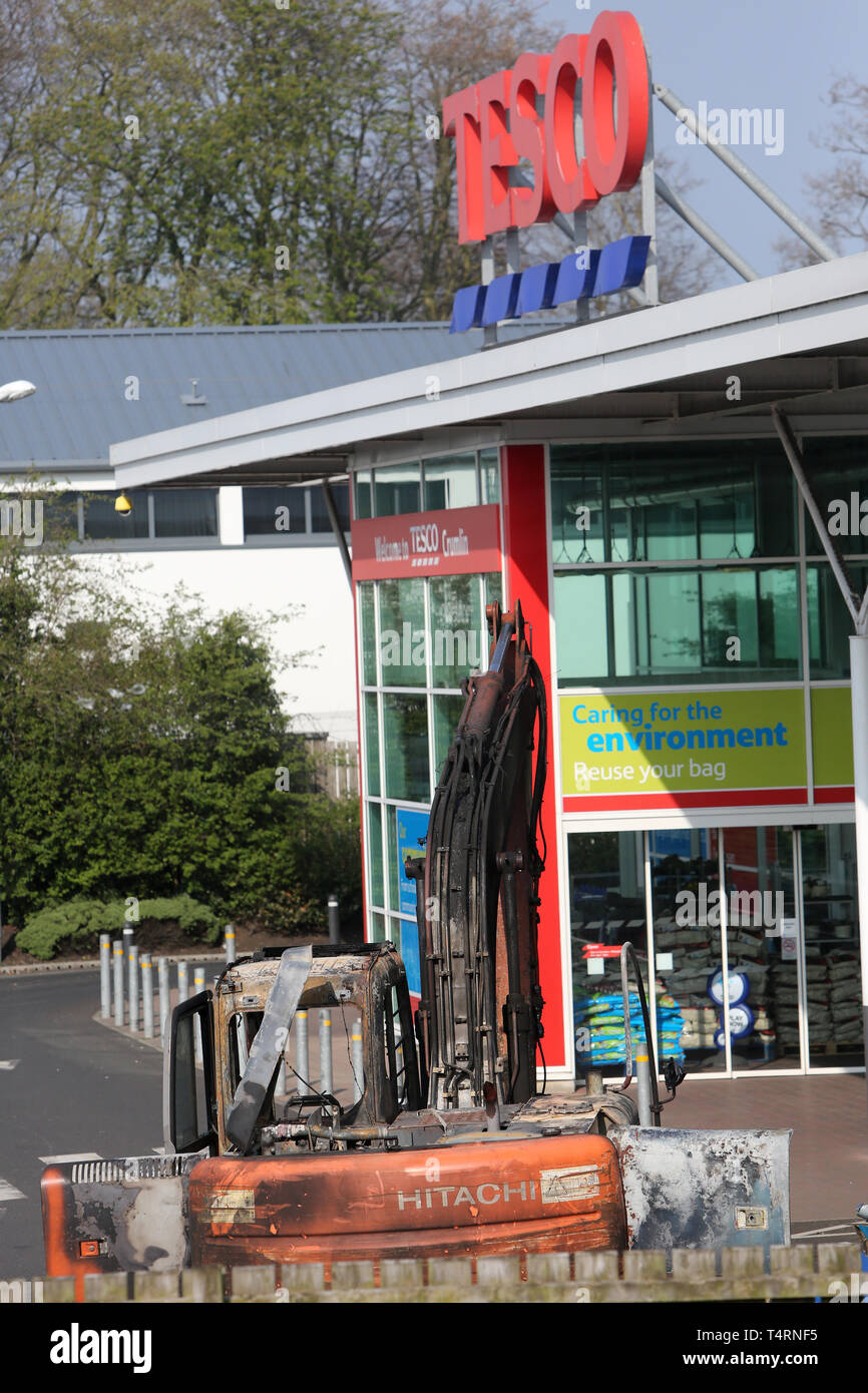 Crumlin, Großbritannien. 19 Apr, 2019. CRUMLIN, County Antrim, Nordirland, 19/April/2019 - Polizei aus der PSNI und Forensik kommen an einem der beiden Tatorten nach einem anderen ATM Diebstahl in einem Supermarkt in Crumlin Dorf, County Antrim. Ein Bagger war steigen und einen Traktor und Anhänger Set wurde auch heraus gefunden verbrannt Sperrung der Hauptstraße in die frühen Morgenstunden. Vier Geldautomaten, 3 aus Nordirland und einer aus dem Süden von Irland, wo in den frühen Morgenstunden gestohlen. Credit: Paul McErlane/Alamy leben Nachrichten Stockfoto