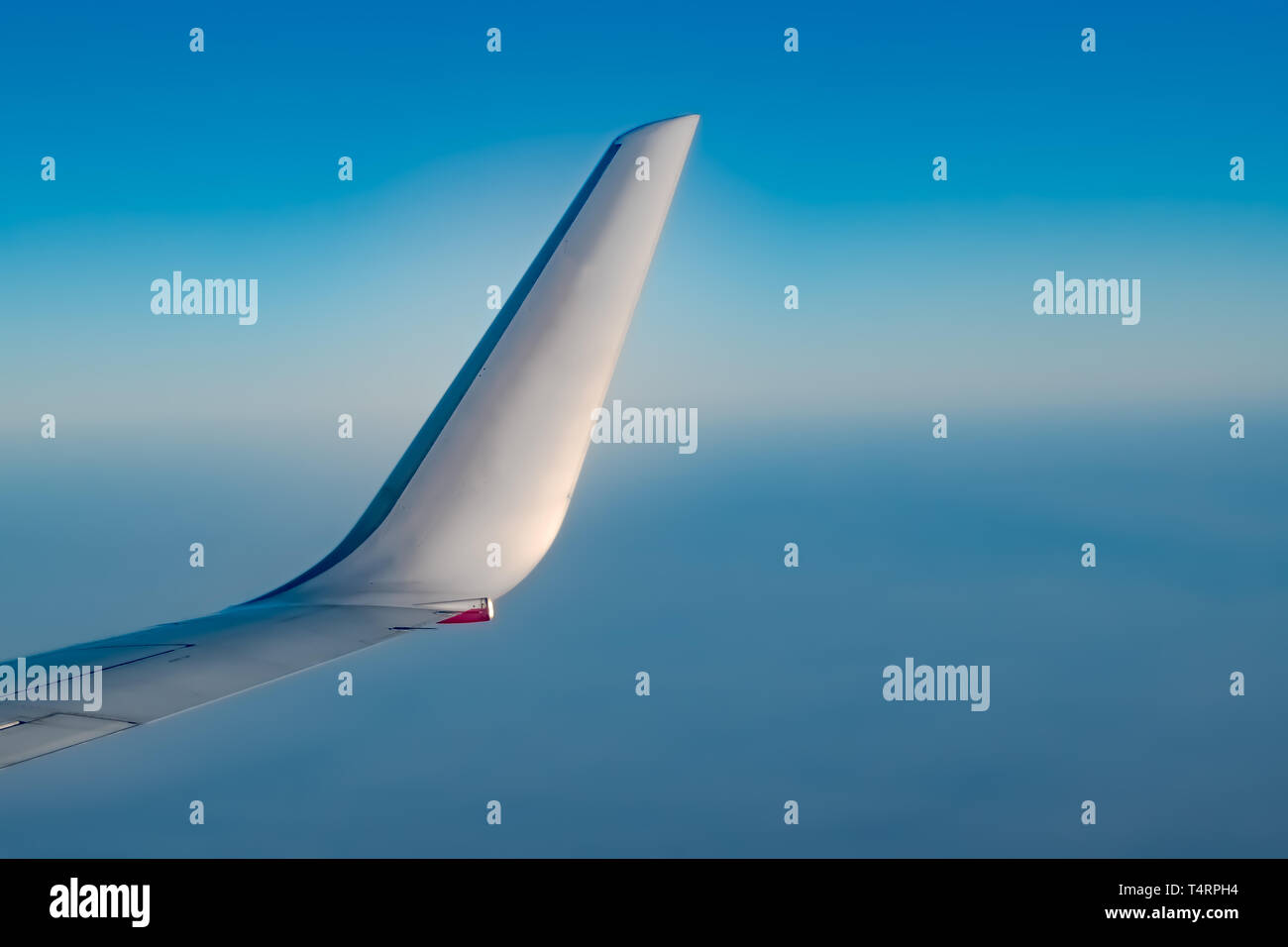 Schöne Winglet eines Flugzeugs, aus dem Fenster Seite aufgegriffen, bei Flugreisen in Höhenlage mit kristallklarem blauen Atmosphäre außerhalb des Fensters Stockfoto