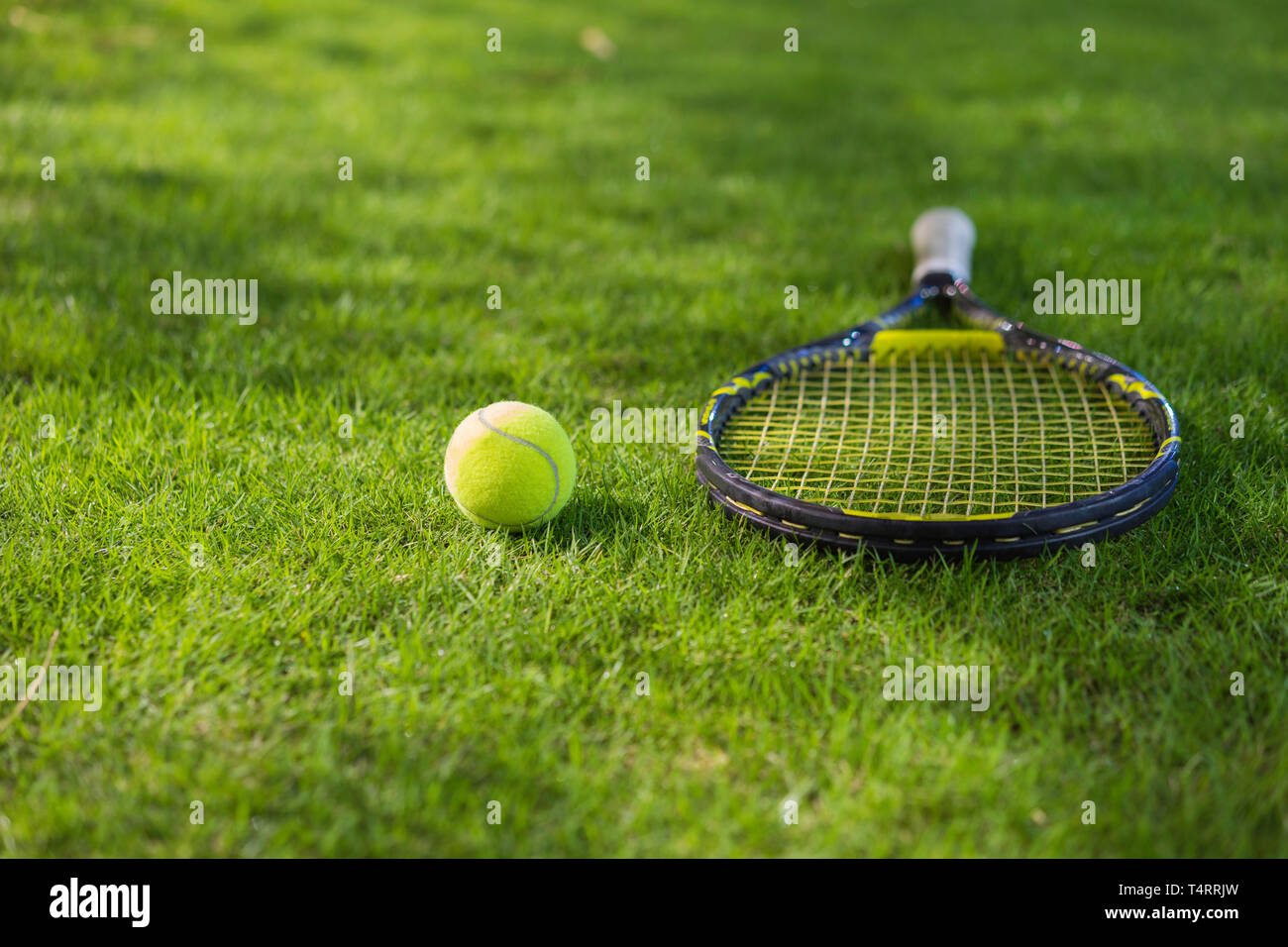 Tennis ball mit Schläger auf nassem Gras nach regen Stockfotografie - Alamy