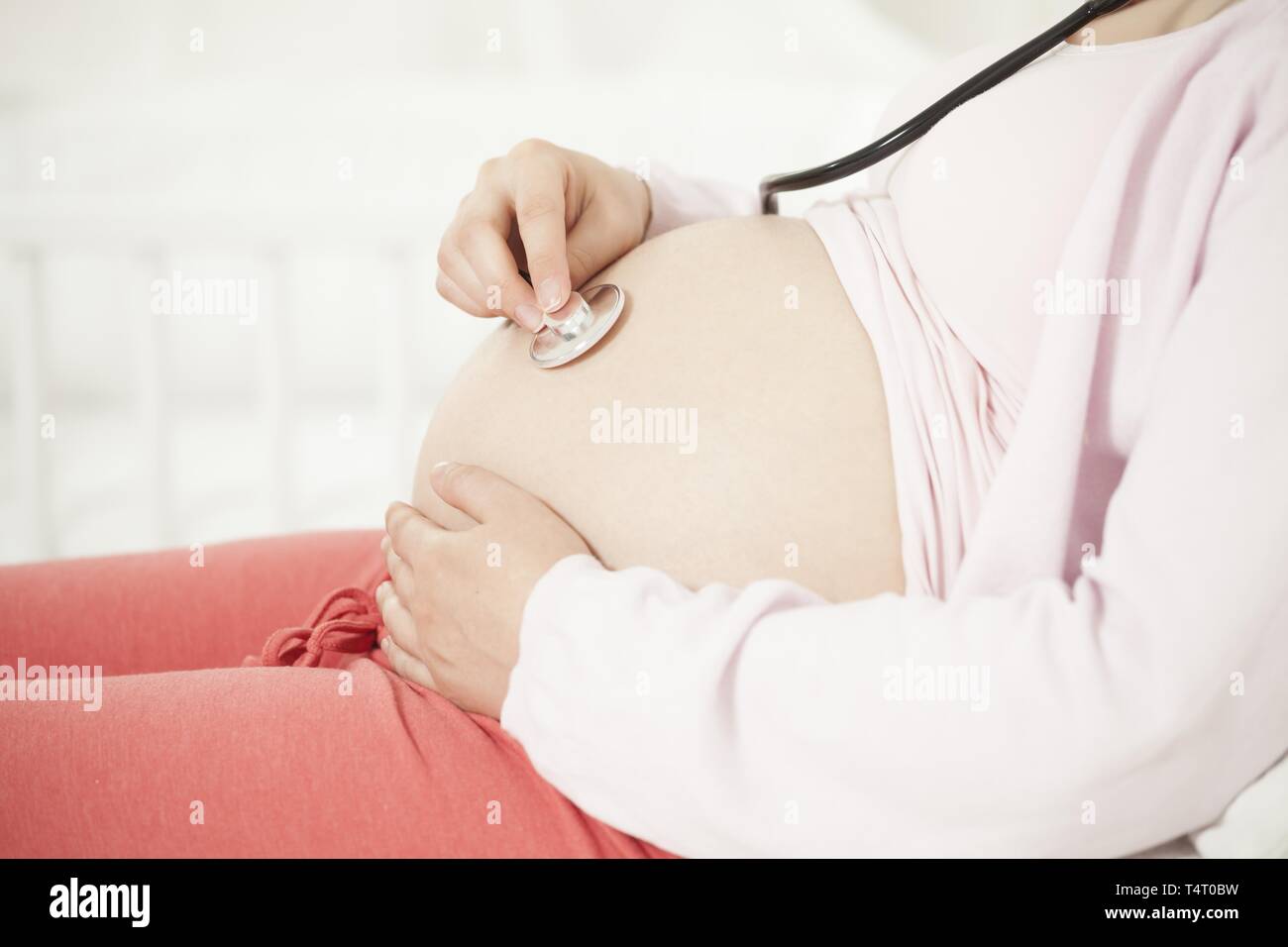 Schwangere Frau mit Stethoskop auf baby Bauch Stockfoto
