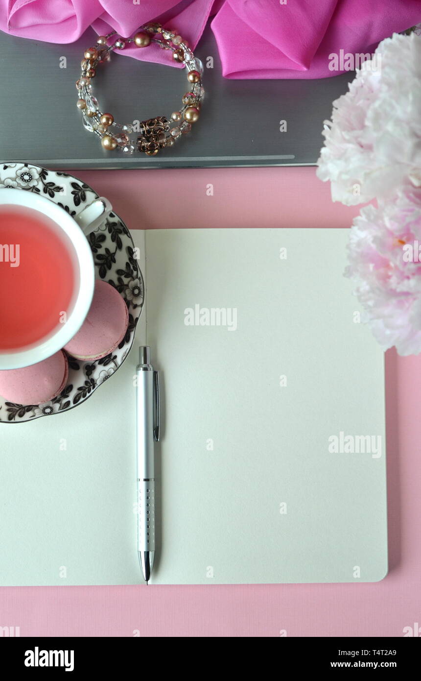Elegant Gestalteten weiblichen Desktop - Entspannung, Lesen, kreatives Schreiben, Lernen und Journaling Konzept mit rosa Pfingstrosen, Obst Kaffee schickes Zubehör Stockfoto