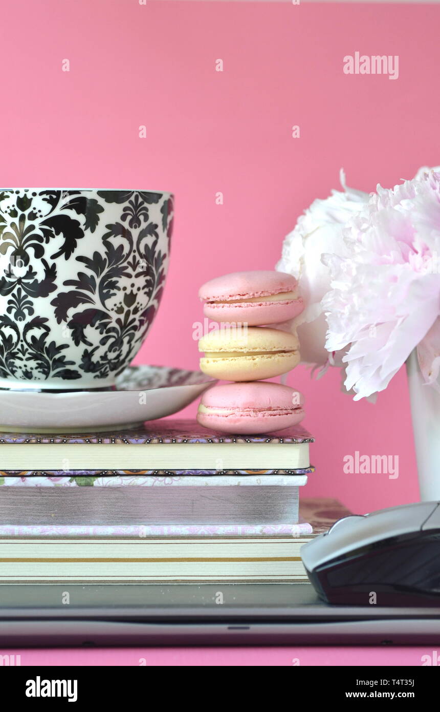 Elegant Gestalteten weiblichen Desktop - Entspannung, Lesen, kreatives Schreiben, Lernen und Journaling Konzept mit rosa Pfingstrosen, Obst Kaffee schickes Zubehör Stockfoto
