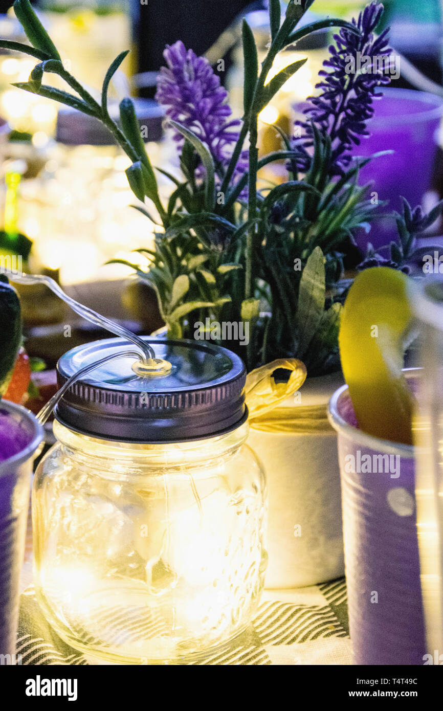 Lavendelblüten mit Lichtern auf einem Tisch umgeben, Nahaufnahme Stockfoto