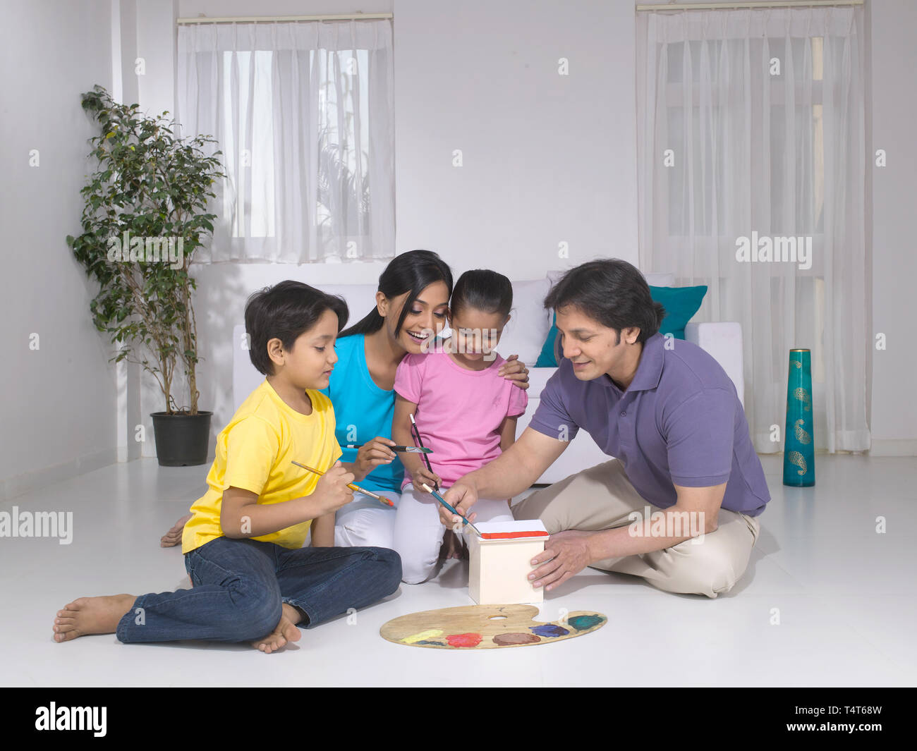 Indische FAMILIE VON 4 Malerei ein Spielzeug HAUS IN IHREM HAUS Stockfoto