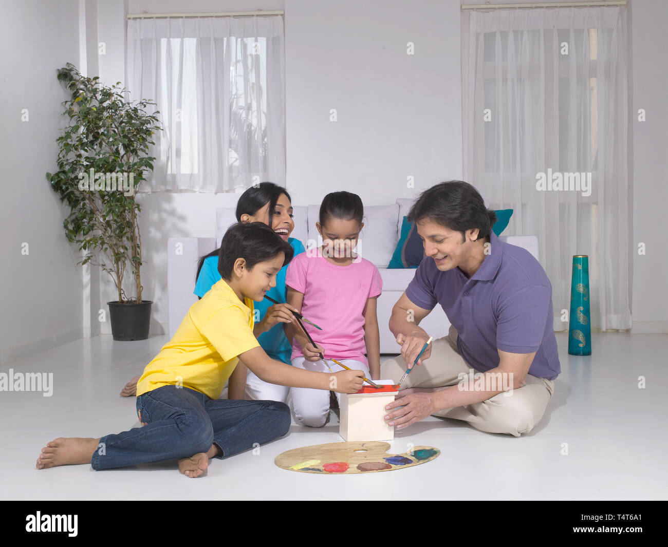 Indische FAMILIE VON 4 Malerei ein Spielzeug HAUS IN IHREM HAUS Stockfoto