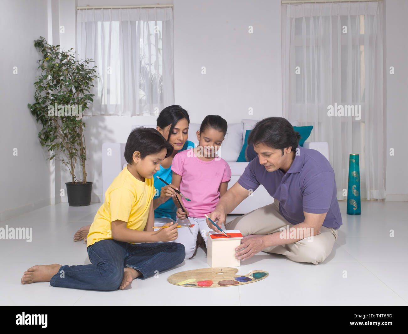 Indische FAMILIE VON 4 Malerei ein Spielzeug HAUS IN IHREM HAUS Stockfoto