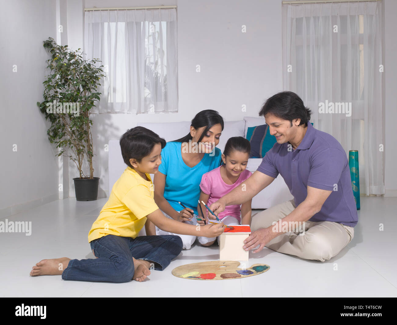 Indische FAMILIE VON 4 Malerei ein Spielzeug HAUS IN IHREM HAUS Stockfoto