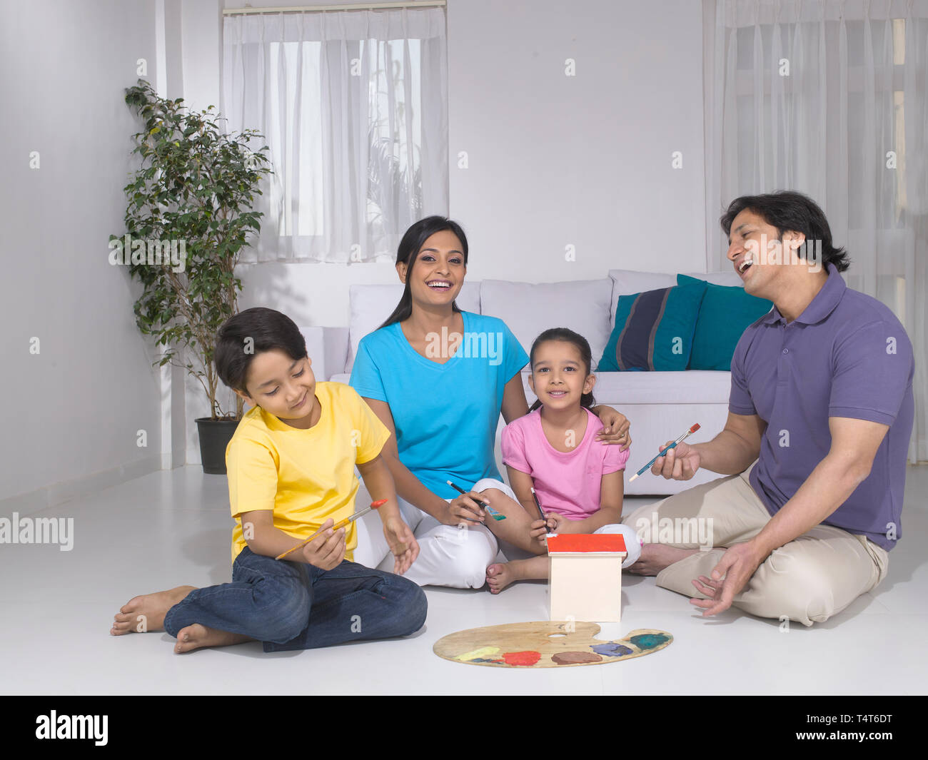 Indische FAMILIE VON 4 Malerei ein Spielzeug HAUS IN IHREM HAUS Stockfoto