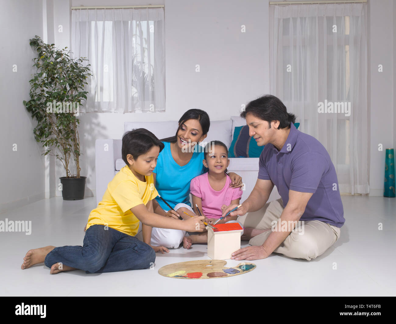 Indische FAMILIE VON 4 Malerei ein Spielzeug HAUS IN IHREM HAUS Stockfoto