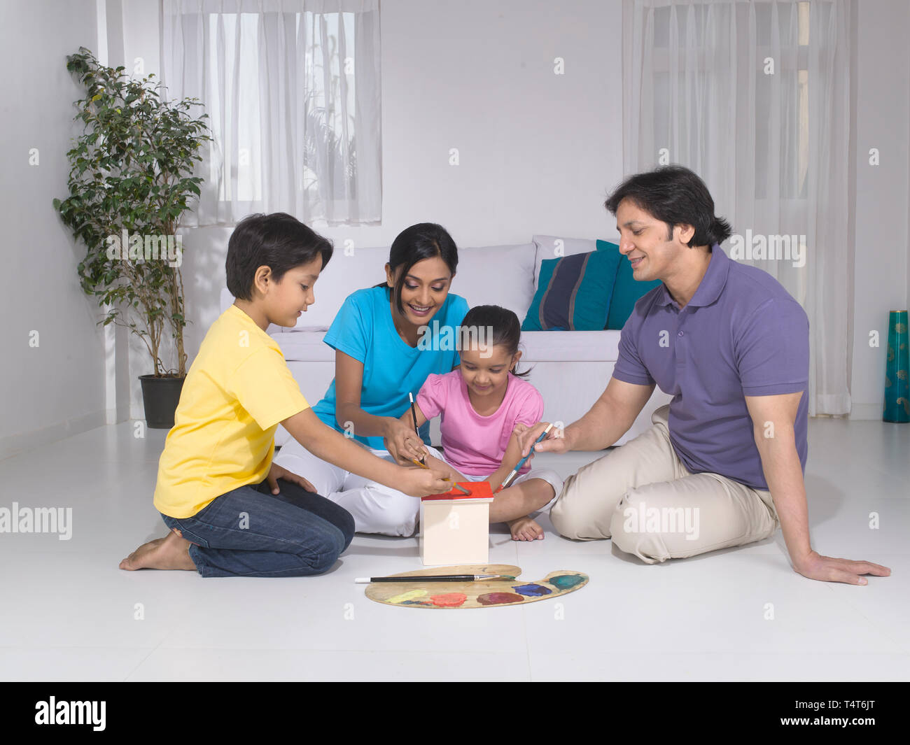 Indische FAMILIE VON 4 Malerei ein Spielzeug HAUS IN IHREM HAUS Stockfoto