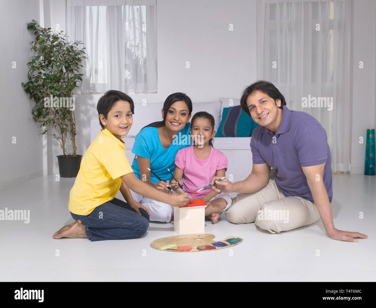 Indische FAMILIE VON 4 Malerei ein Spielzeug HAUS IN IHREM HAUS Stockfoto