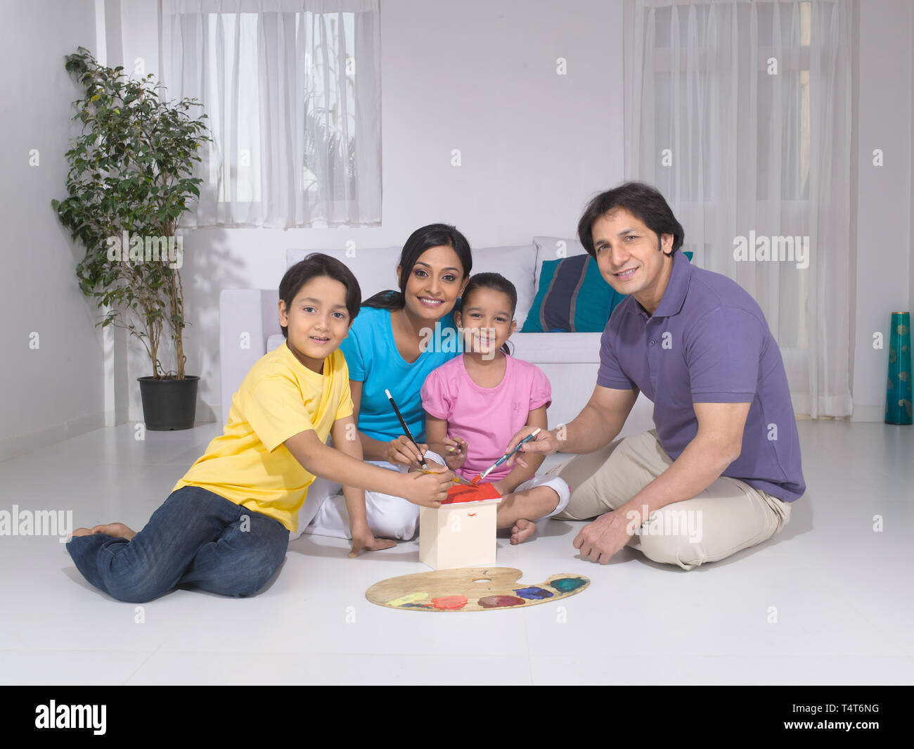 Indische FAMILIE VON 4 Malerei ein Spielzeug HAUS IN IHREM HAUS Stockfoto
