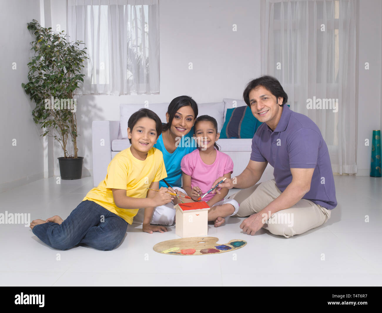 Indische FAMILIE VON 4 Malerei ein Spielzeug HAUS IN IHREM HAUS Stockfoto