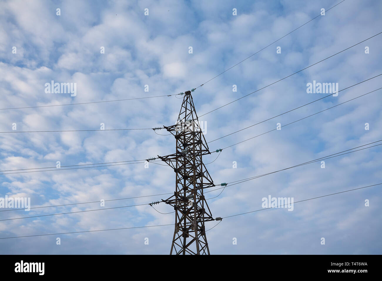Unterstützt die Hochspannungs-Leitungen gegen den blauen Himmel mit Wolken. Elektro-Industrie. Stockfoto