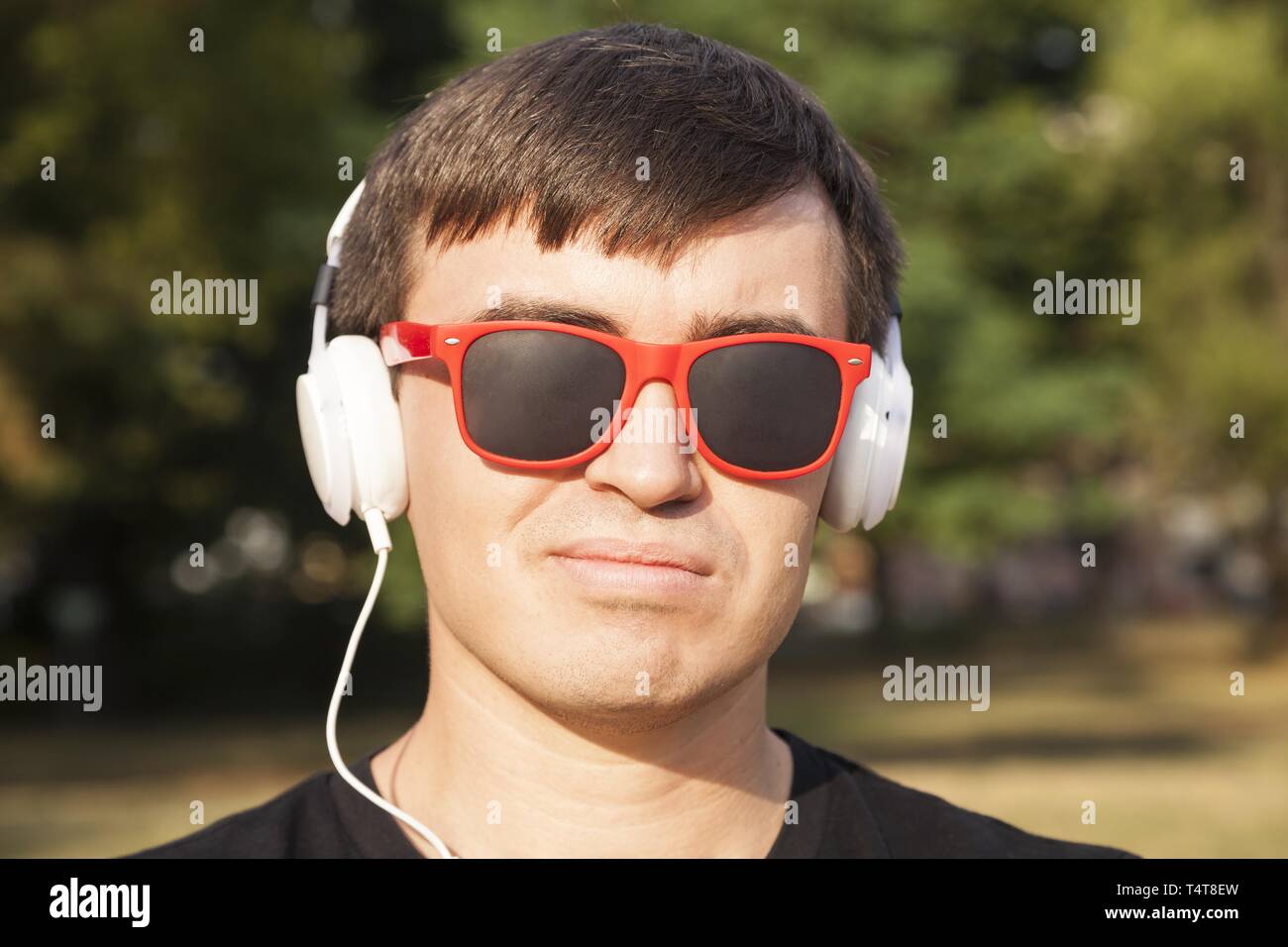 Junger Mann mit Sonnenbrille und Kopfhörer, Deutschland Stockfoto