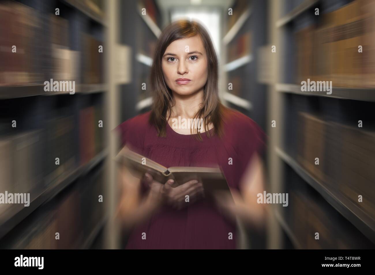 Schüler mit Buch in der Bibliothek (verschwommen Effekt) Stockfoto