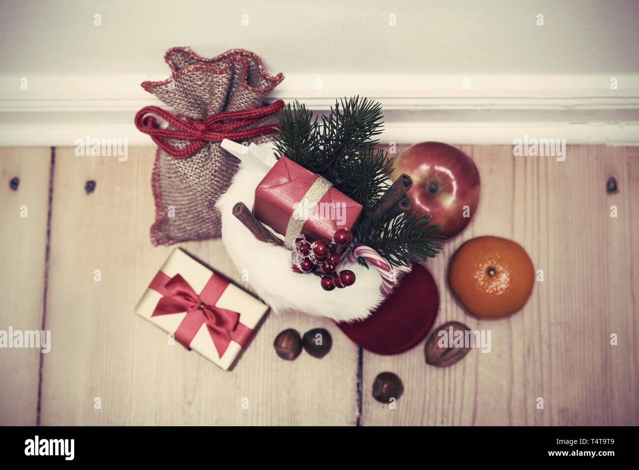 Weihnachtsstiefel auf dem Boden, Geschenke Stockfoto