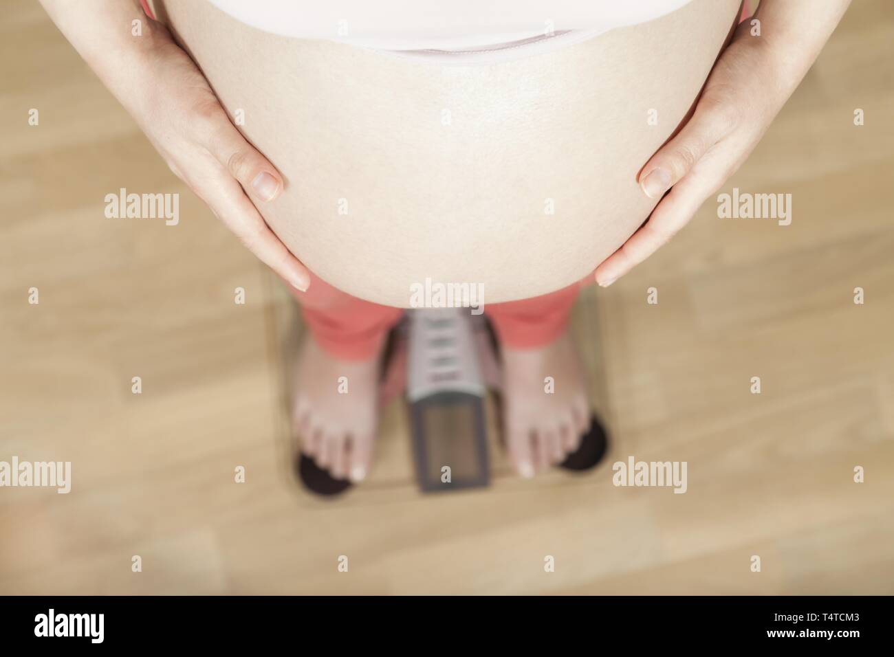 Schwangere Frau auf einer Waage Stockfoto