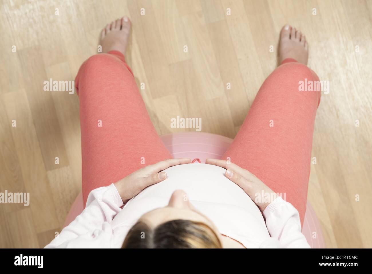 Schwangere Frau sitzt auf einer übung Kugel, von oben Stockfoto