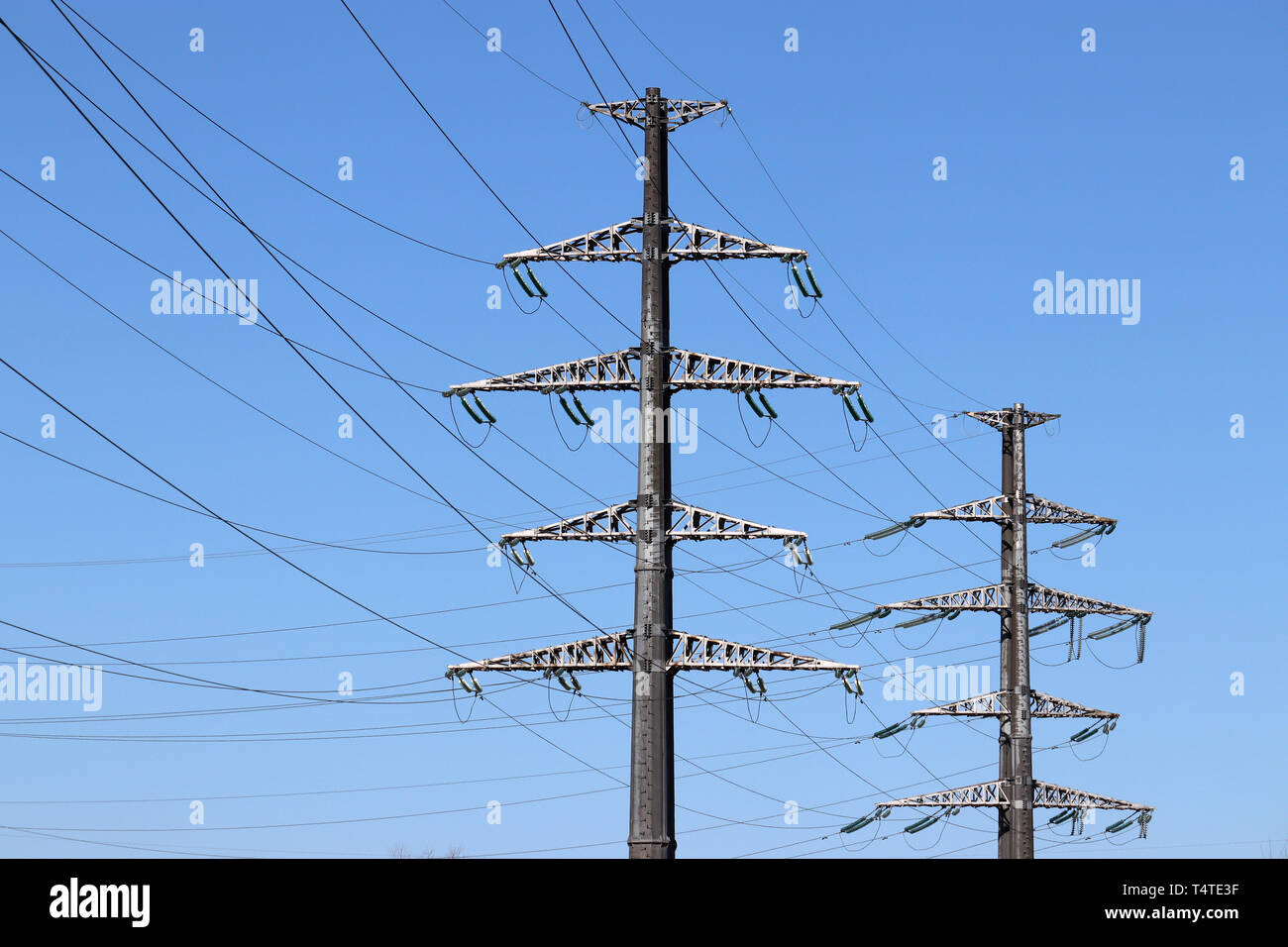 Power Line unterstützt mit elektrischen Kabeln am klaren, blauen Himmel Hintergrund. Hohe Spannung Fernleitungen, Konzept der Stromversorgung Stockfoto