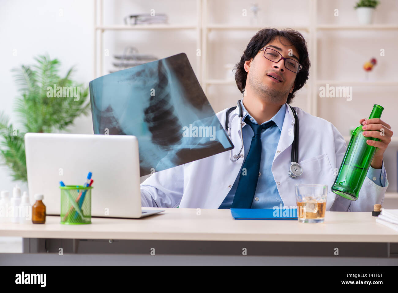 Junge männliche Arzt trinken im Büro Stockfoto