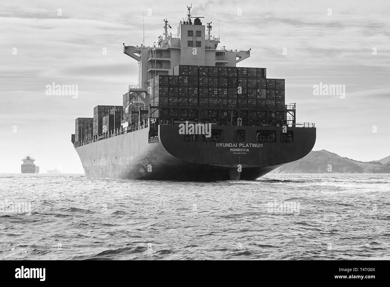 Schwarz-weiß Foto von den riesigen Containerschiff, Hyundai Platin, dampfende durch die belebten Osten Lamma Versand Kanal, Hong Kong. Stockfoto