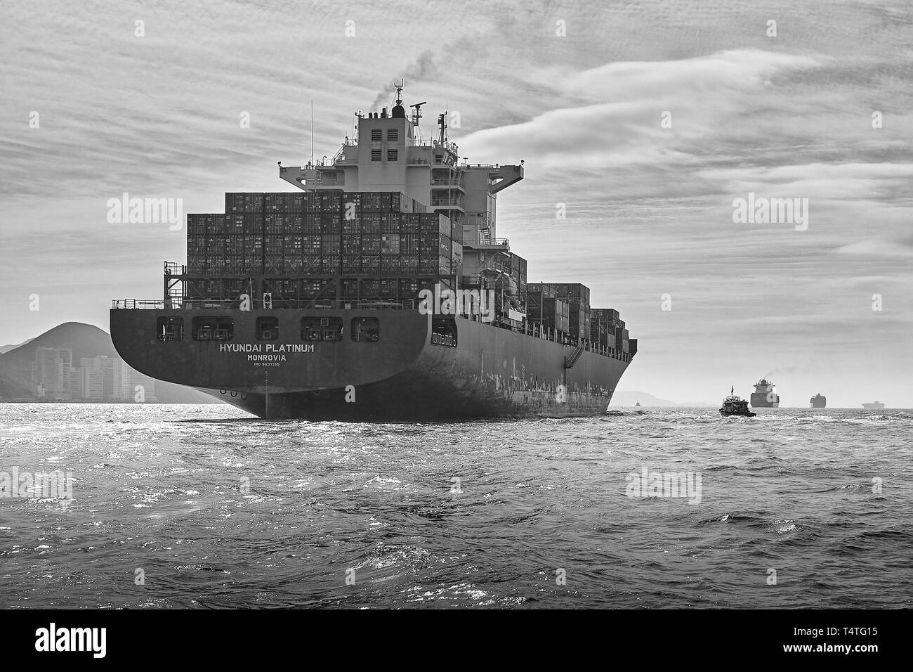 Moody Schwarz-Weiß-Foto Des Containerschiffs Hyundai Platinum, Unterwegs Im Geschäftigen East Lamma Shipping Channel, Hongkong. Stockfoto