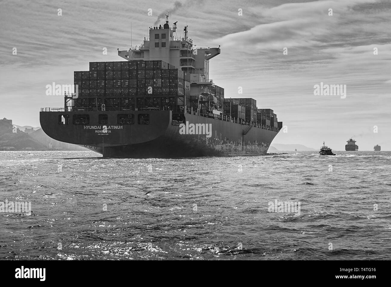 Moody Schwarz-Weiß-Foto Des Containerschiffs Hyundai Platinum, Unterwegs Im Geschäftigen East Lamma Channel, Hongkong. Stockfoto