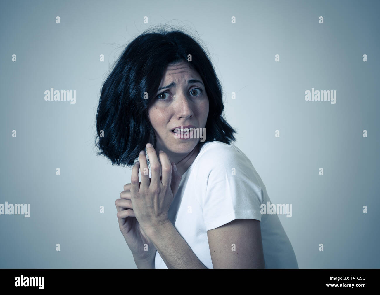 Nahaufnahme der jungen Frau mit erschrockenen Augen, schockiert, kauerte, zurückschrecken. Schaut entsetzt und verzweifelt. Menschen und die Ausdrücke und Gefühle c Stockfoto