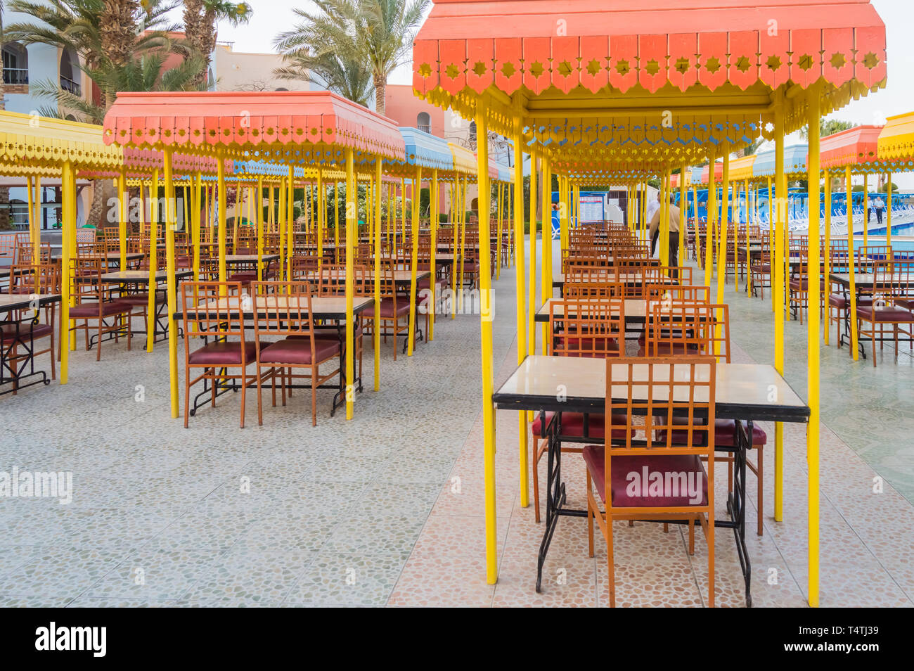 Das hölzerne Restaurant Terrasse mit Tischen mit vier Sitze mit einem kleinen Dach gegen die Sonne. Stockfoto