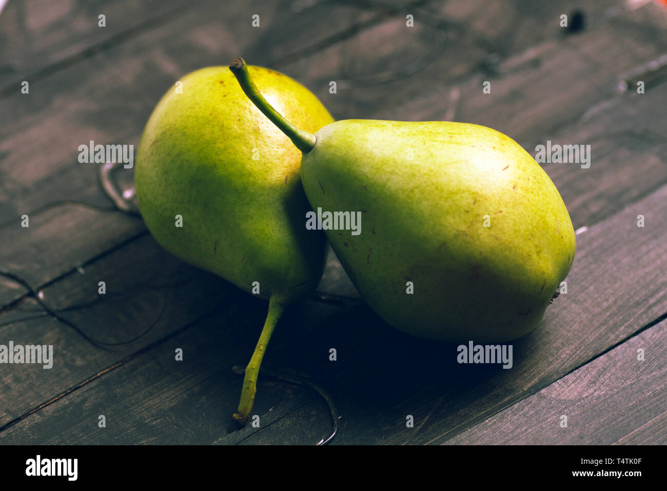 Birnen zu essen mit einem hölzernen Messer und auf braunem Hintergrund ausschneiden Stockfoto