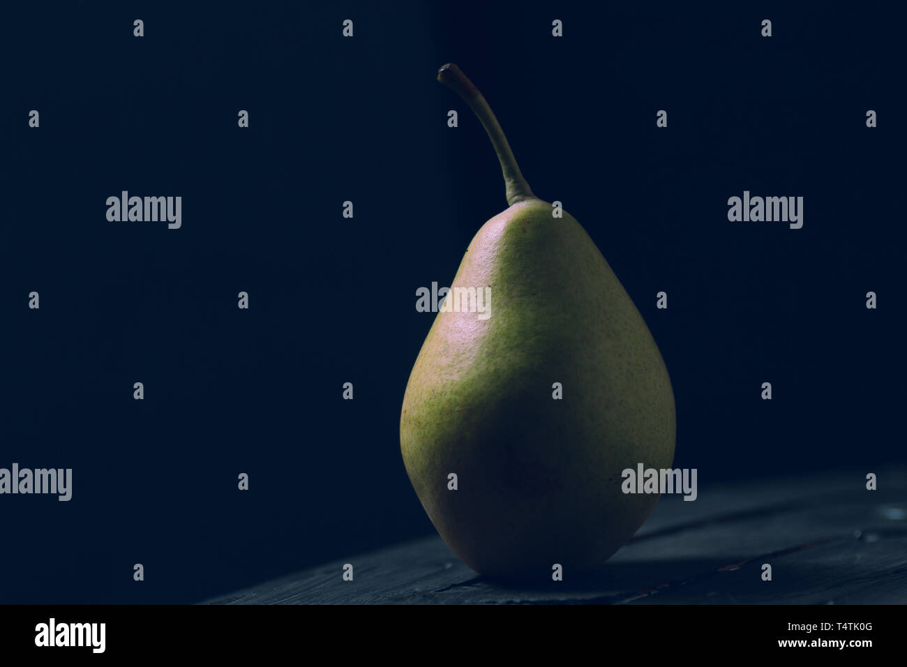 Birnen zu essen mit einem hölzernen Messer und auf braunem Hintergrund ausschneiden Stockfoto