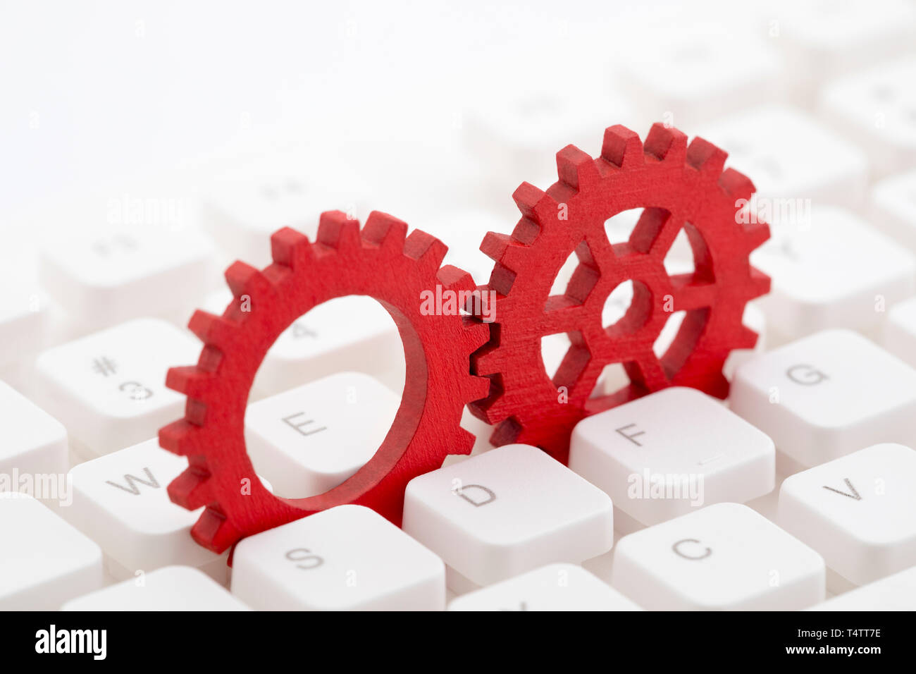 Zwei rote Zahnräder auf Computer Tastatur Stockfoto