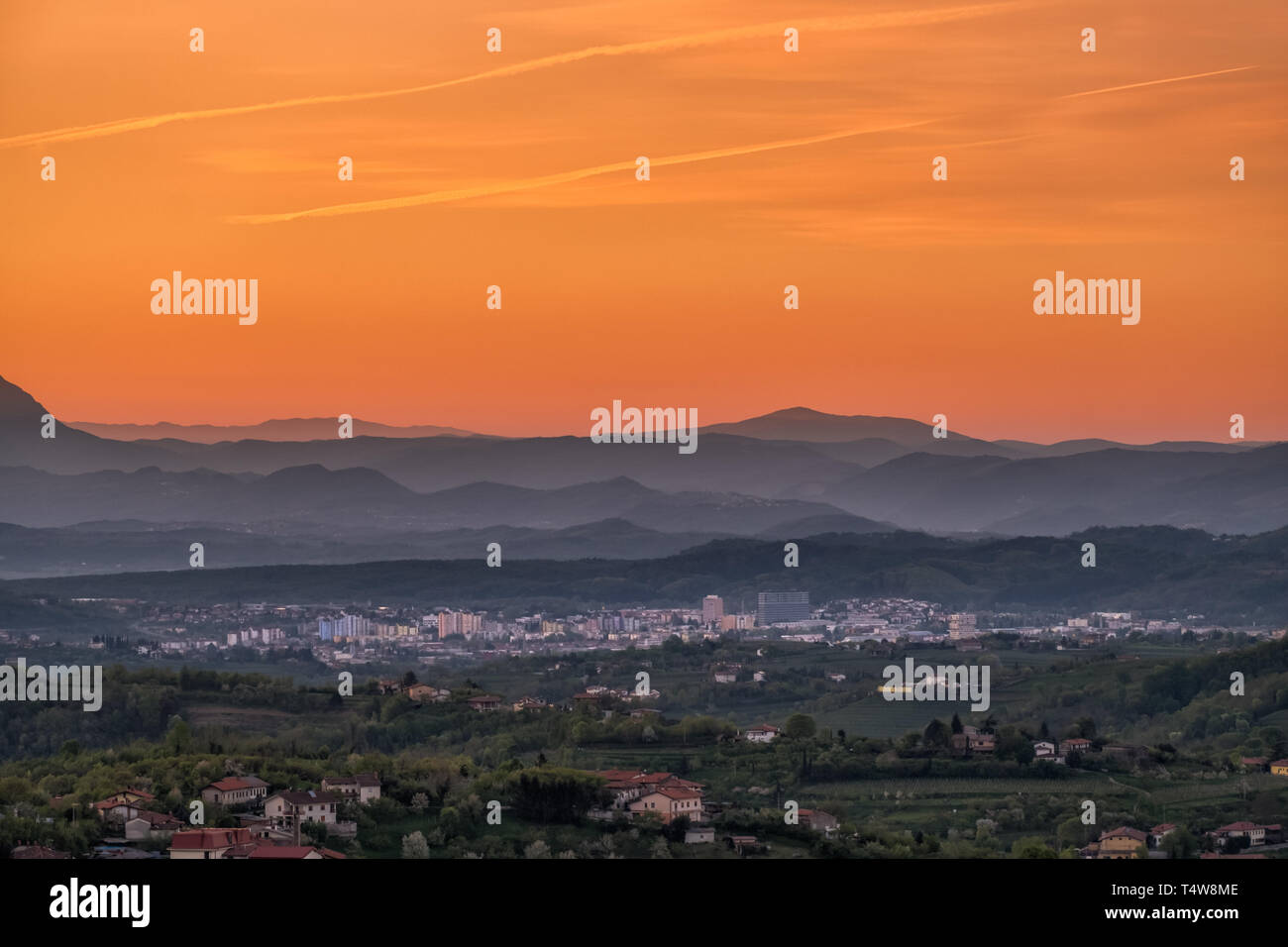 Blick über Weinberge in Wein Region Goriška Brda auf sunrise in die Stadt Nova Gorica mit der Julischen Alpen und des Triglav National Park in Slowenien in der Nähe der Grenze zu Italien in der Eu Stockfoto