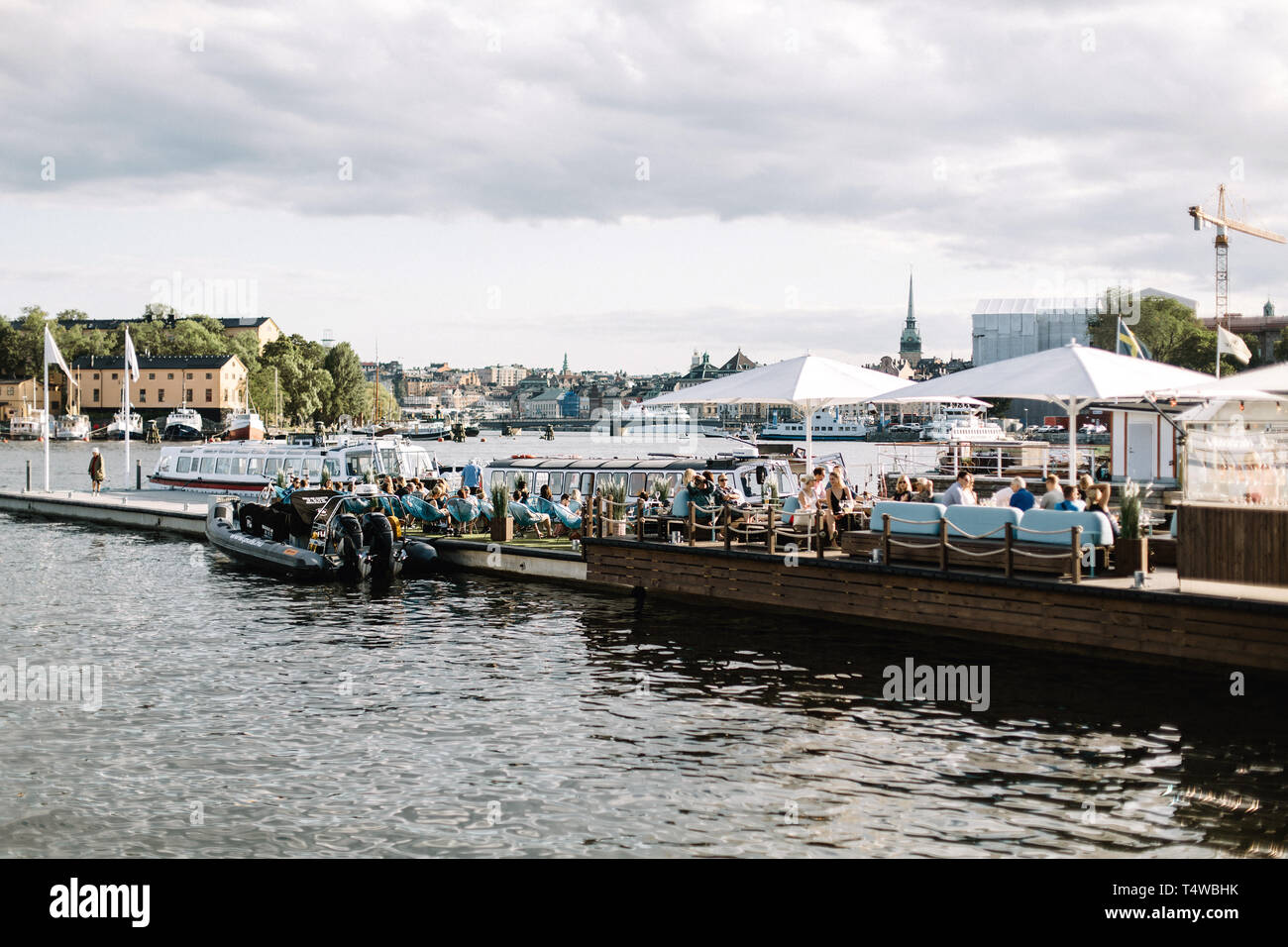 Die Menschen genießen einen warmen Tag Sommer auf einen Hafen mit Blick auf die Ostsee in Stockholm, Schweden Stockfoto