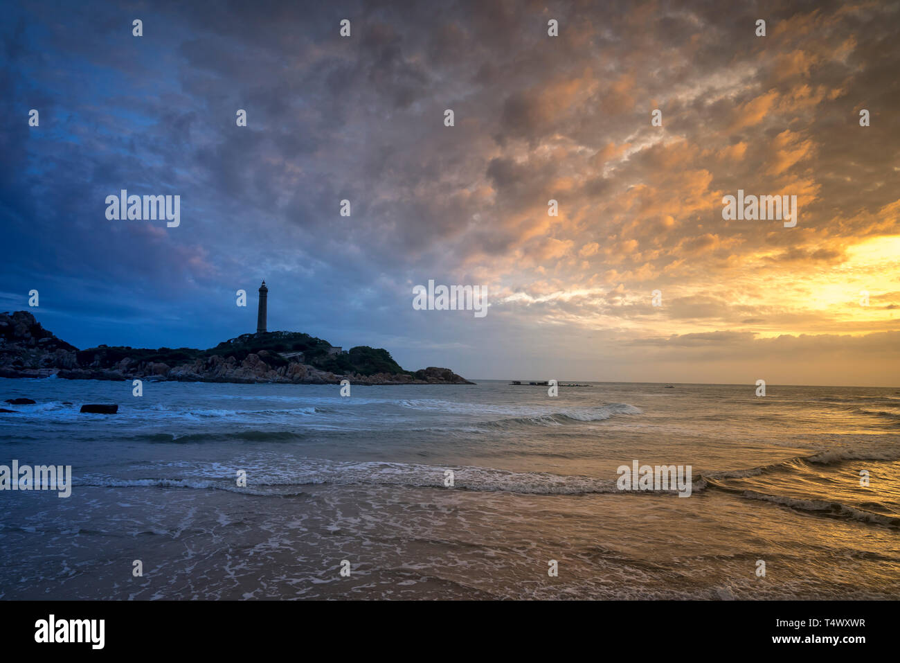 Anzeigen von Ke Ga Leuchtturm bei Sonnenuntergang mit der magischen Wolken. Ke Ga Leuchtturm auf einer kleinen Insel in Ninh Thuan Provinz, Vietnam Stockfoto