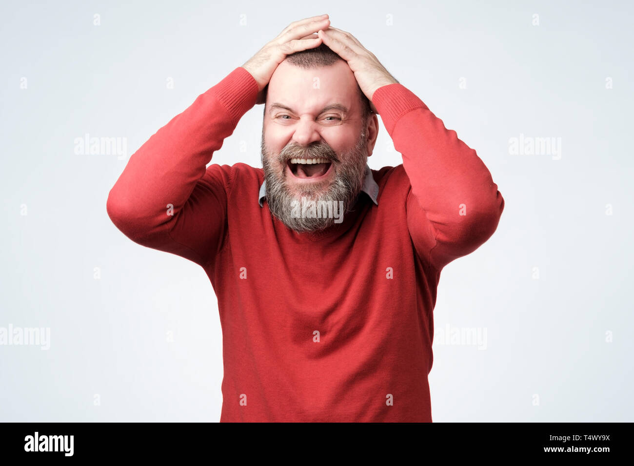 Schöne reife bärtiger Mann im roten Pullover lachen Stockfoto