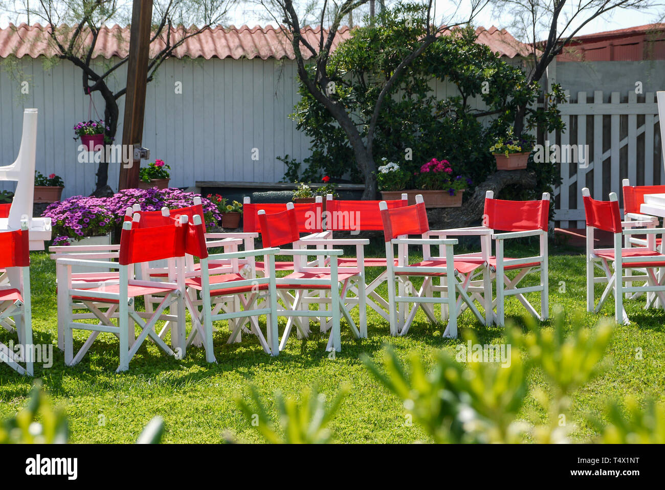 Klappbare weiße und rote Sessel im Garten eines Badehauses am Strand von Tarquinia Lido, in Italien Stockfoto