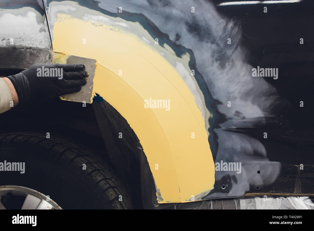 Vorbereitung für die Lackierung eines Autos mit schmirgel Absender ein Service Techniker, Nivellierung, bevor Sie eine Grundierung nach der Beschädigung auf einen Teil des Bsb Stockfoto